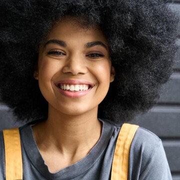 Beautiful African American female with curly healthy hair styled with avocado oil and aloe vera gel