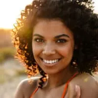 Young African American woman with a curly hair type styled with Cantu shea butter and Cantu curl activator cream.