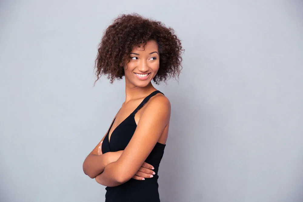 Pretty lady with her arms folded with mildly damaged hair from heat styling tools.