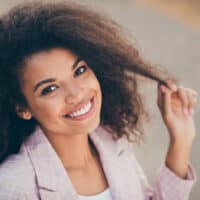 Cute light-skin black lady in a business suit with oily hair styled with Herbal Essences salon products.