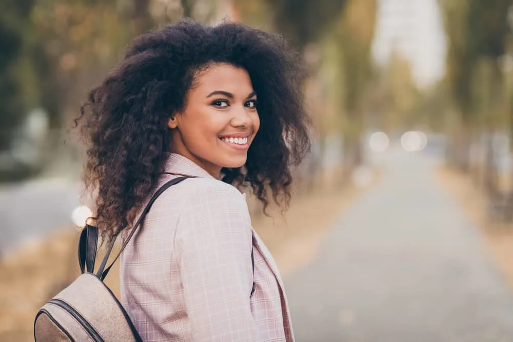 A woman walking in the park after school after finishing her college classes.