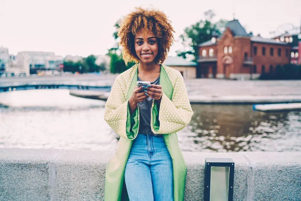 Beautiful black female with blonde and medium brown hair color in her naturally curly strands.