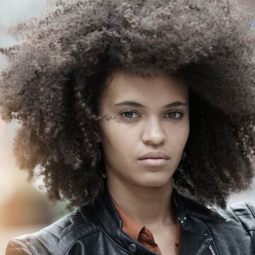 Mixed-raced lady with medium brown hair wearing a black leather jacket