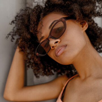 A dark-skinned woman with a new haircut showing off her perfectly styled wash n go hairdo.