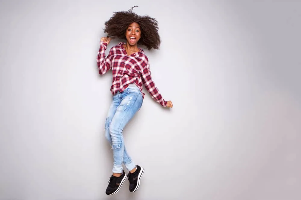 Excited young black woman celebrating after obtaining a barber license and during a certified cosmetology program.