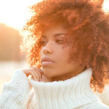 Beautiful African American girl with naturally dark brown hair colored with red hair dye.