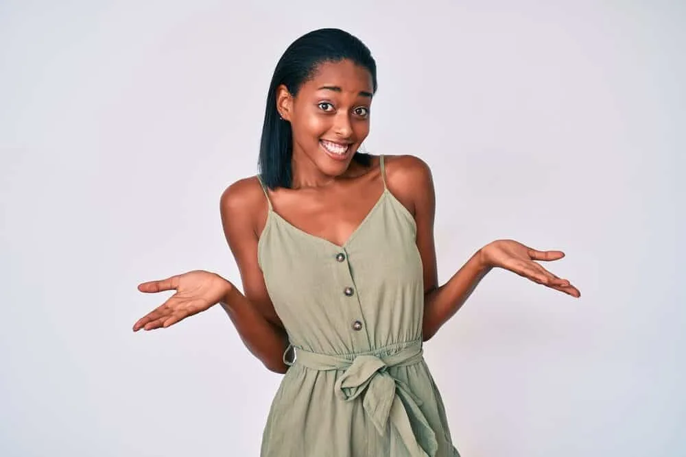 Young African American female wearing a green casual outfit with 4B curls that have been straightened.