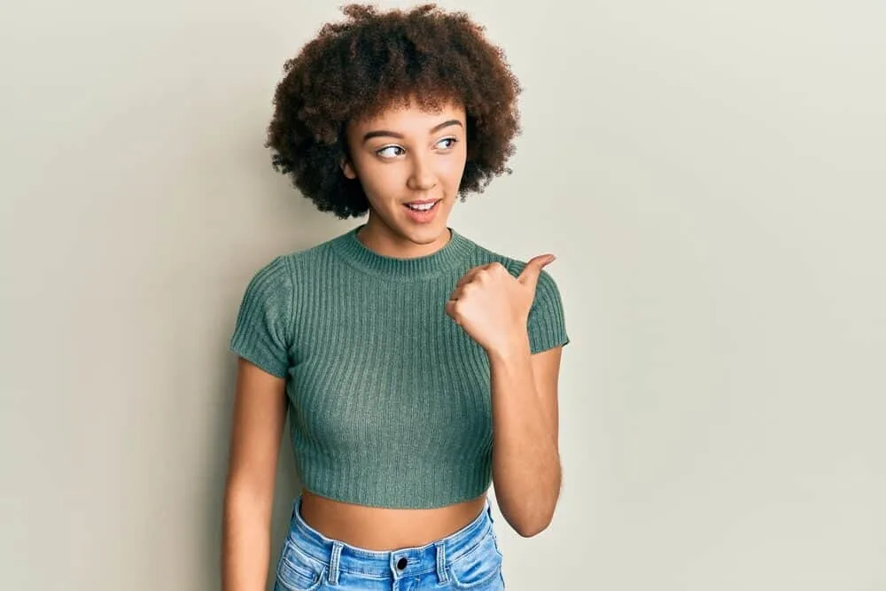 Cute Hispanic girl with long curly hair styled with natural oils and aloe vera gel wearing casual clothes.