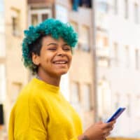 Young girl leaving a professional hair stylist with a blue hair color after a semi-permanent dye treatment.