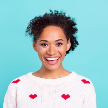 African American female wearing permanent hair dye on dark brown natural hair with pink lipstick.