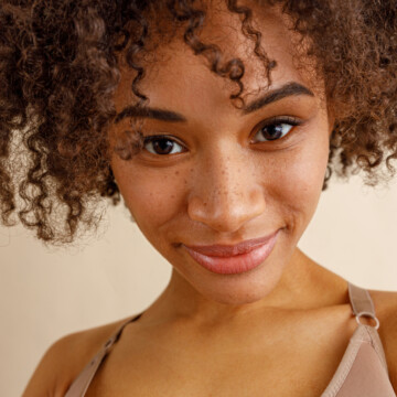 Beautiful mixed race lady with cute freckles and curly hair styled with hair powder.