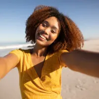 Black girl with dyed natural hair extensions with edges styled with hair gel.