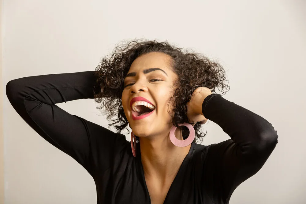 Pretty black girl with 3A curls treated with essential nutrients and flic acid from organic moringa.