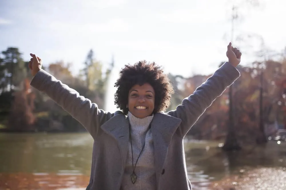 African American woman at the park with a 4A kinky afro styled with unrefined oil and aloe vera gel.