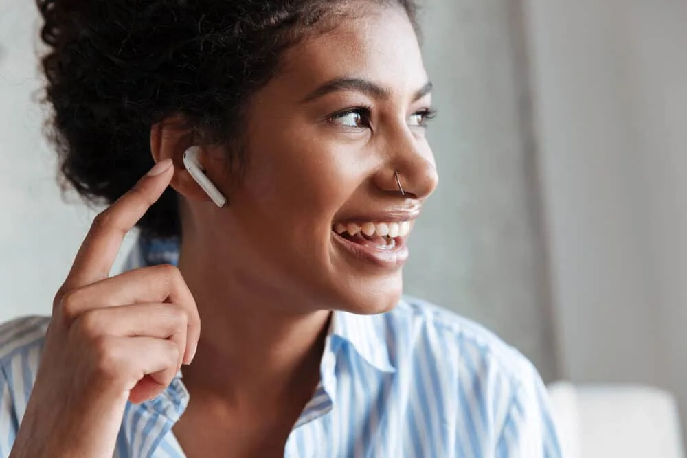 Black lady talking on the phone to her hair stylist about the risks associated with dyeing virgin hair at home.