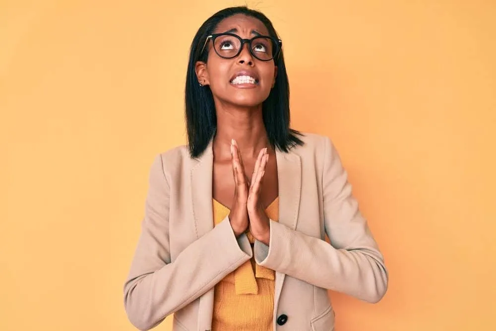 African American woman wearing a beige business suit and shiny hair after blow-drying her completely straight hair.