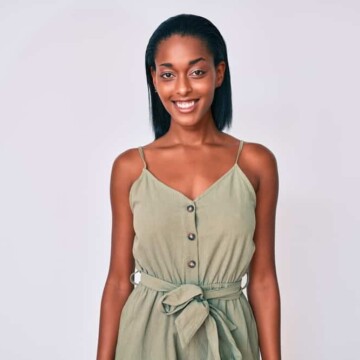 Young African American woman wearing a green jumper after getting a Brazilian Blowout smoothing treatment.