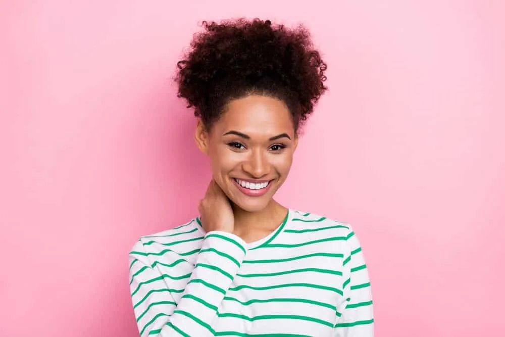 African American female wearing temporary dye on 4A natural curls with a white and green sweater.