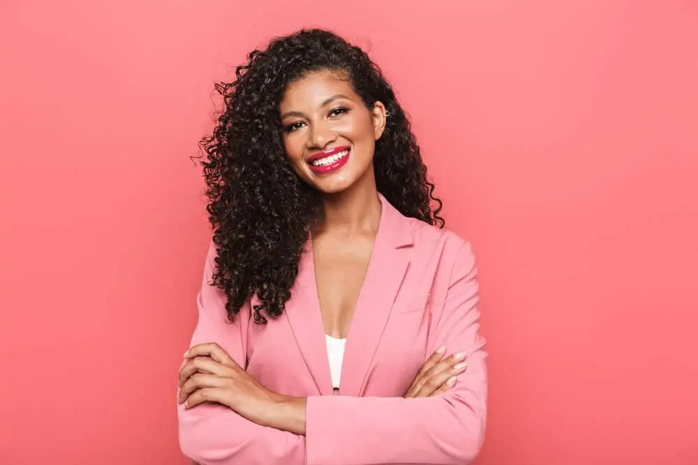 Lovely young black girl wearing Manic Panic dye on dark brown curls with red lipstick and natural makeup.