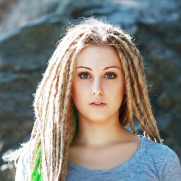 A young white student with blonde dreadlocks created by backcombing her 1B normal hair which is straight.