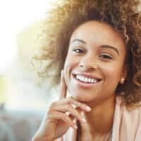 Cute African American female with medium brown hair after using a high-lift hair color treatment on her 4A curls.