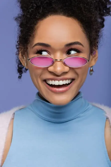 Cute black girl with curly hair follicles wearing a blue shirt.