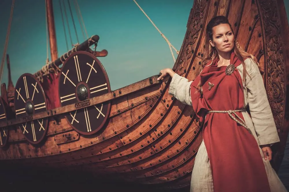 A woman outside of Ancient Egypt posing with a wooden ship.