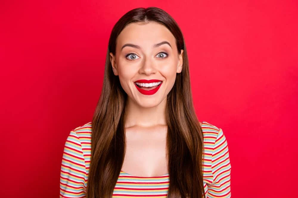 A lady with a straight hair type with a big smile after incorporating the Curly Girl Method for hair growth.