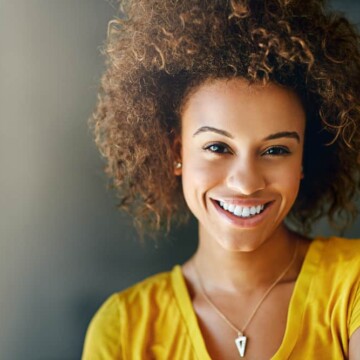 Cute African American female with a light brown hair color with undertones created with dark brown dye.