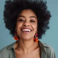 African American female with black hair wearing a green shirt and dark red lipstick.