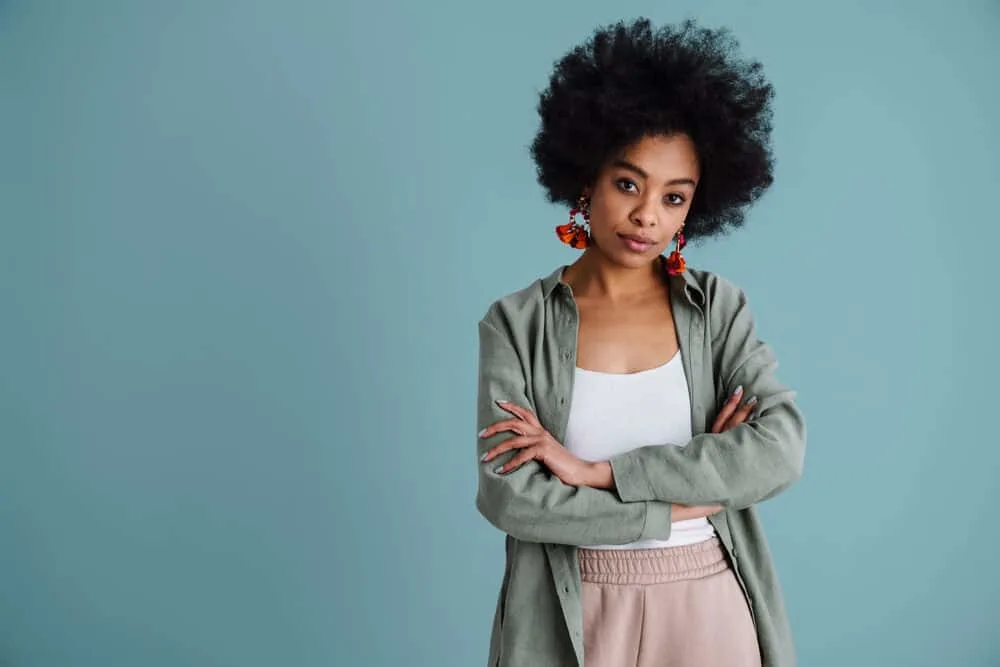 An adult female is wearing a wig over her own natural hair as a protective style.