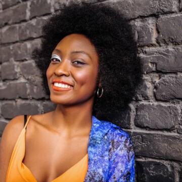 Pretty African American female with healthy natural hair strands wearing an afro hairstyle on a kinky hair type.