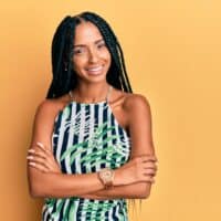 Beautiful Hispanic woman wearing box braids on her 3C natural hair with a blue and green shirt.