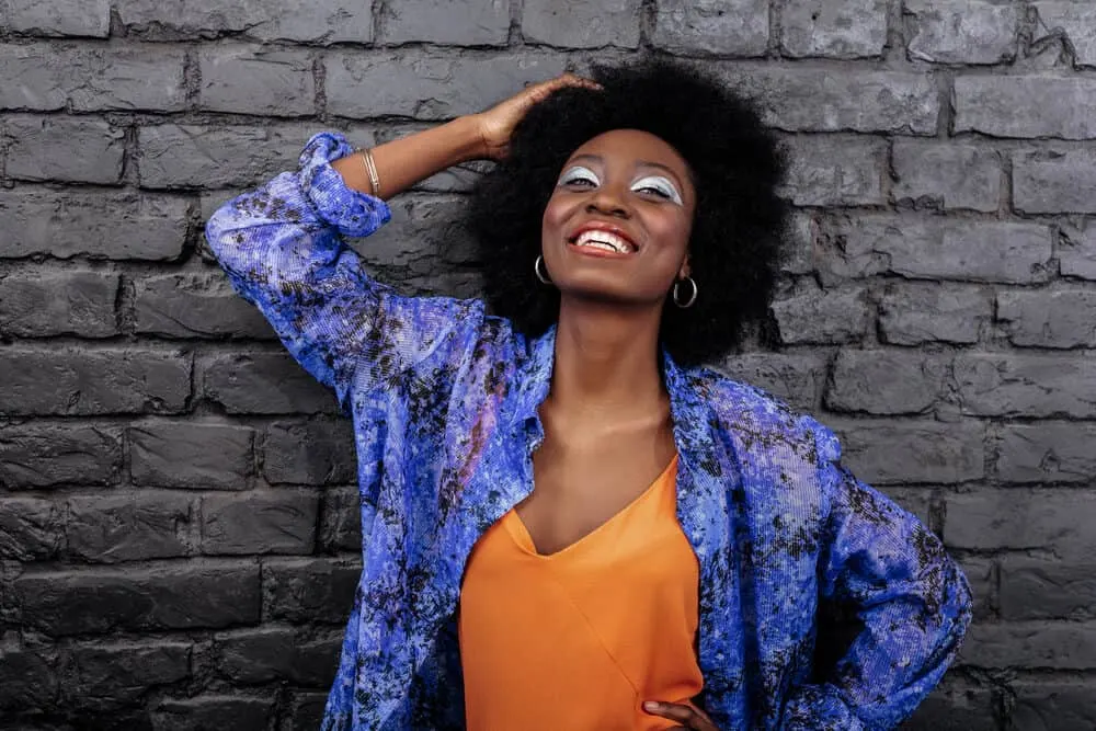 African American female running her fingers through her own hair admiring her hair journey.