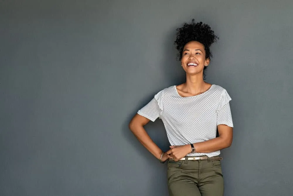 African American girl wearing casual clothes with natural curls treated with essential oil.