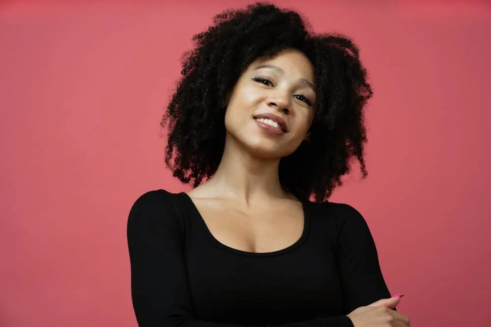 Black lady wearing a stylish wash and go hairdo on high porosity hair treated with protein-free products.