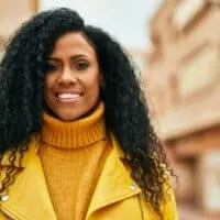 Middle age African American woman with 4C natural hair wearing a full lace wig secured with wig clips.