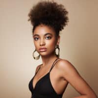 African American female with a dark brown hair color that uses baking soda and hair bleach to lighten her hair.