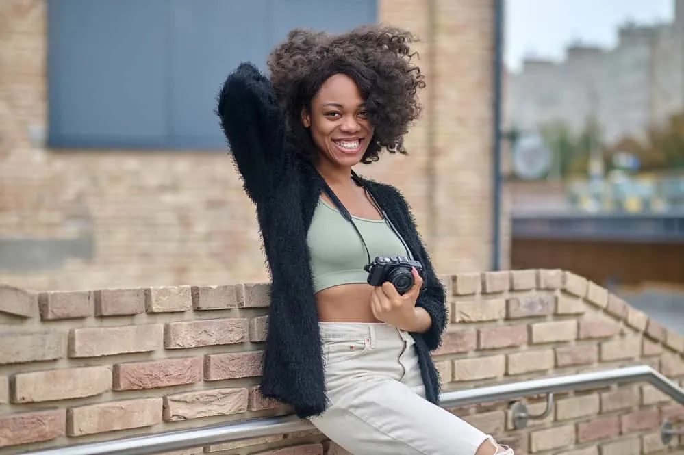 Black lady with thinner hair wearing a sew-in wig that covers her natural hairline and hair style.