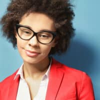 Beautiful African American female with dyed hair strands after undergoing a natural hair coloring treatment.