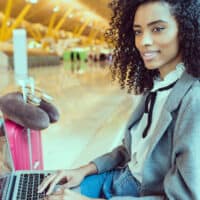 Black female with aerosol hairspray in her carry-on bag preparing to go through transportation security administration.