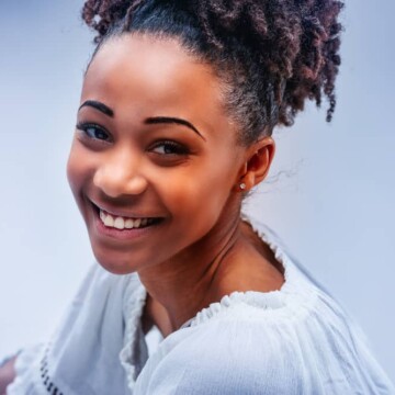 Young African American female wearing a semi-permanent hair color on her bleached hair cuticles.