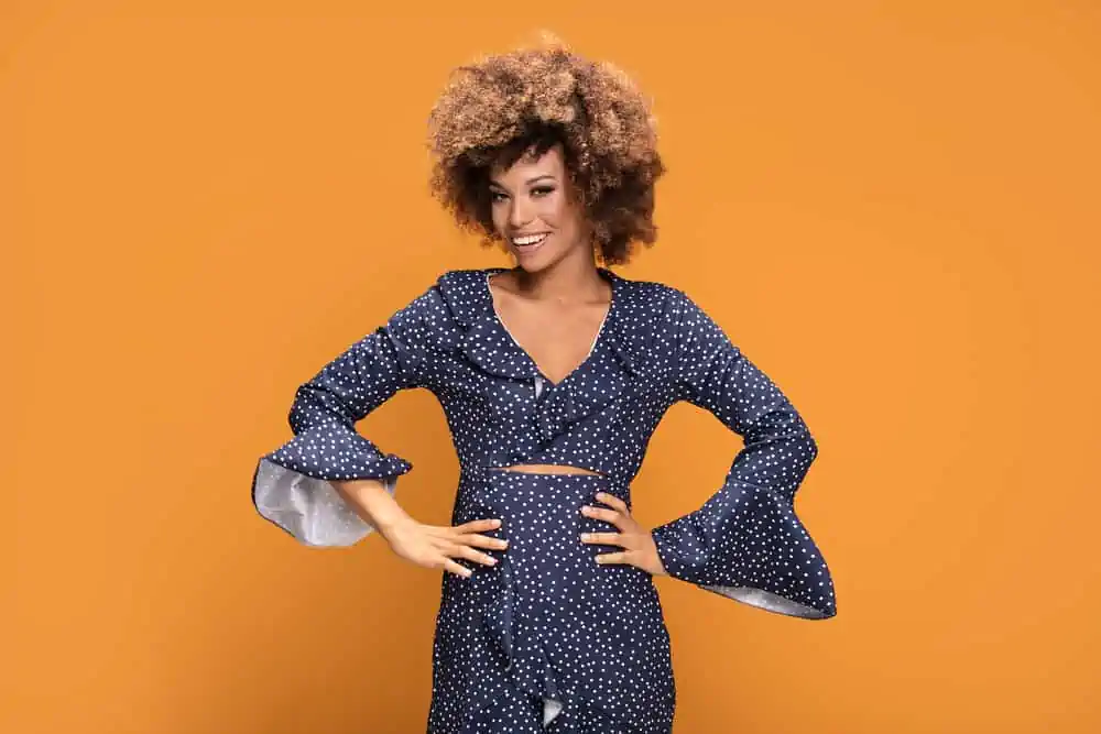 An African American lady posing in a blue and white casual dress with her hair dyed with semi-permanent hair colors.