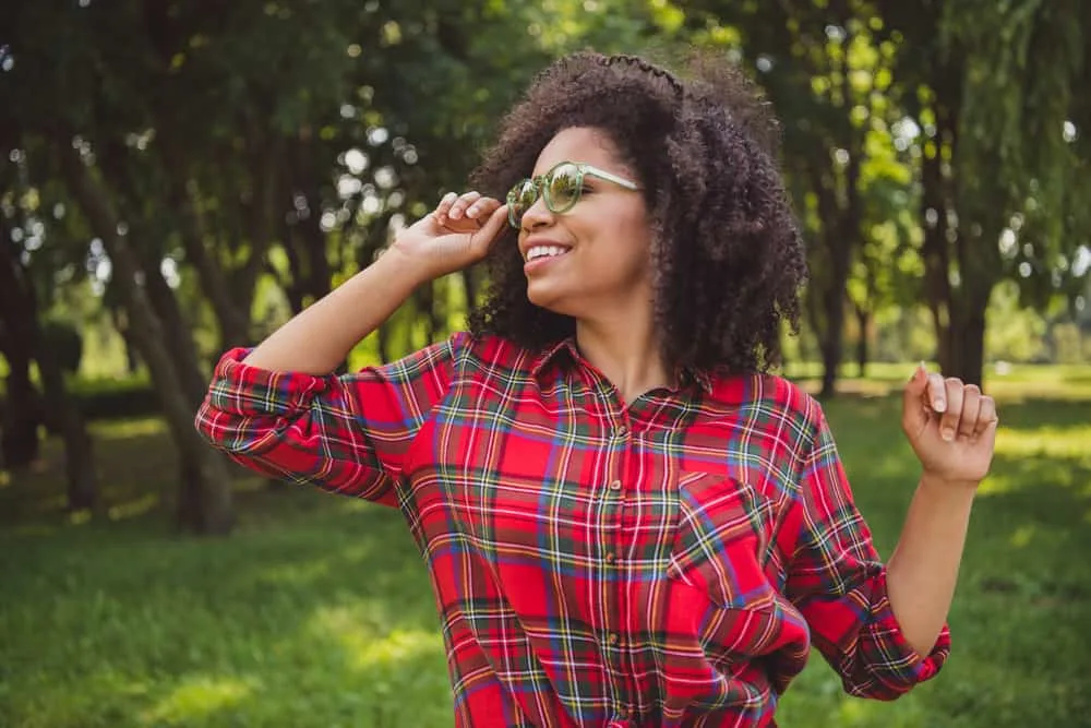 Cute African American female with a 4A curl pattern wearing a layered haircut and a casual outfit.