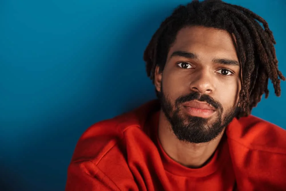 Bearded African American man with his hair follicles in dreadlocks style treated with coconut oil and lemon juice.