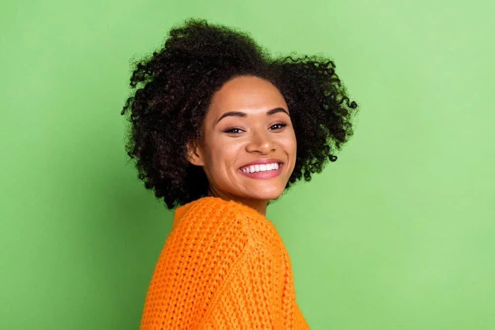 A young black female with dark brown hair that's turned a lighter shade after excessive sun exposure.