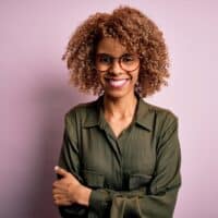 African American female with a reddish-brown hair color after using a semi-permanent hair dye on her natural curls.