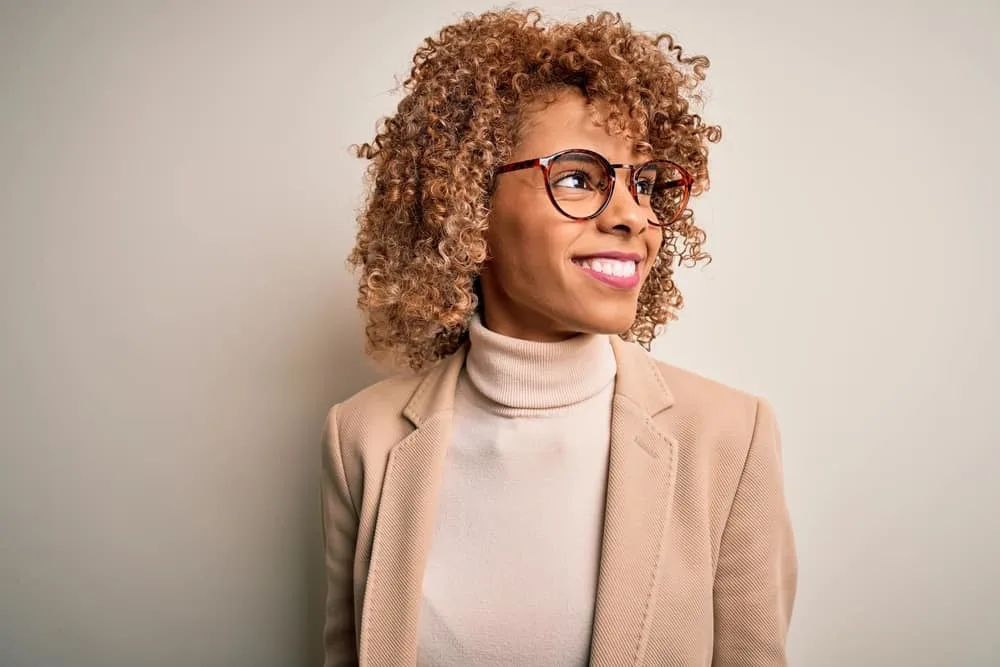 Cute black girl with a great smile wearing pastel pink lipstick after washing her hair with color depositing shampoo.