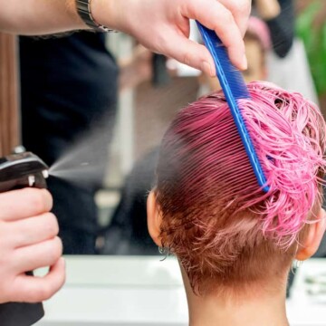 Hairdresser in one of the signature style salons getting a permanent hair color service on thick hair.