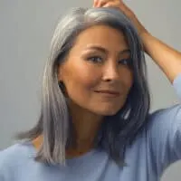 Middle-aged Asian female with natural gray hair follicles that were covered up with permanent hair dye.